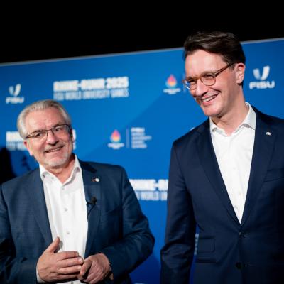 NRW-Ministerpräsident Hendrik Wüst und Mülheims Oberbürgermeister Marc Buchholz beim Head of Delegation Dinner die FISU-Fackel im Mülheimer Luftschiffhangar.