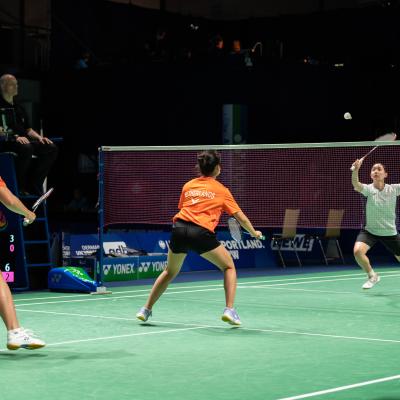 Badminton-Spieler bei der FISU auf einem grünen Spielfeld in der Mülheimer Westenergie Sporthalle