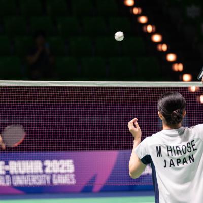 Badminton-Spieler bei der FISU auf einem grünen Spielfeld in der Mülheimer Westenergie Sporthalle
