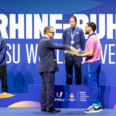 Sportdezernent David Lüngen bei der Medaillenübergabe an die Gewinnerinnen Frauen Einzelbei der FISU in der Mülheimer Westenergie Sporthalle