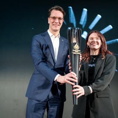 NRW-Ministerpräsident Hendrik Wüst überreichte beim Head of Delegation Dinner im Mülheimer Luftschiffhangar die FISU-Fackel an die Hip-Hop-Weltmeisterin Stella Ritter.