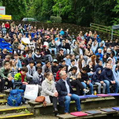 die Schüler der Mülheimer Europaschulen sitzen auf der Freilichtbühne und schauen sich die Aufführung an 