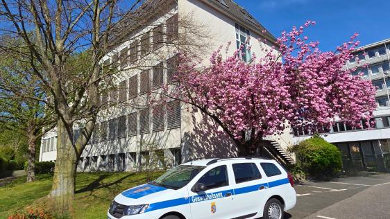 Der Dienstwagen des Gesundheitsamtes steht auf einem Parkplatz vor dem Gesundheitsamt. 
