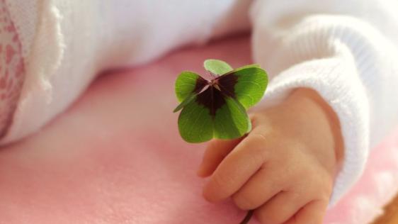 Babyhand mit Kleeblatt
