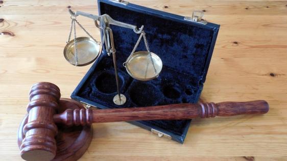 Bildausschnitt mit einem Richterhammer und einer Waage in einem geöffneten Kästchen. Gerichtsverfahren, Recht, Gerechtigkeit, Justiz