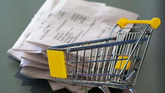 Kassenbon und leerer Einkaufswagen. Infos zu Hilfe zum Lebensunterhalt