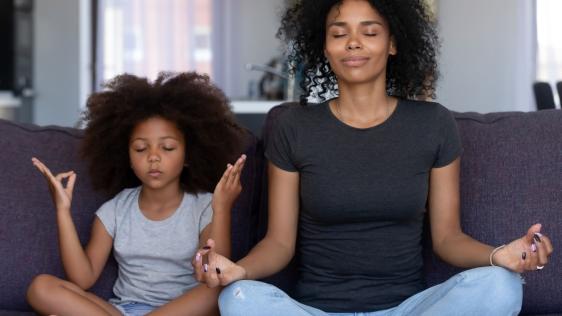 Mutter und Tochter zusammen im Yoga-Schneidersitz.
