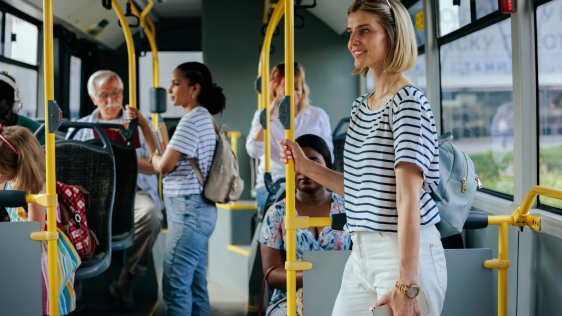 Mehrere Personen stehen und sitzen in einem öffentlichen Verkehrsmittel