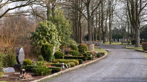 Sarg-Erdgrabstätte auf dem Friedhof Styrum entlang eines Weges