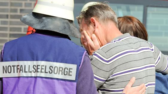 Der Notfallseelsorger kümmert sich um einen Betroffenen.