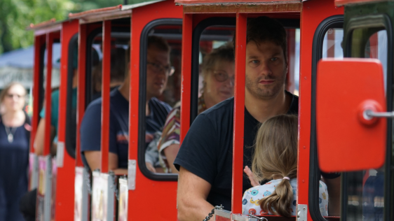 Eine rote Kindereisenbahn mit Besuchenden