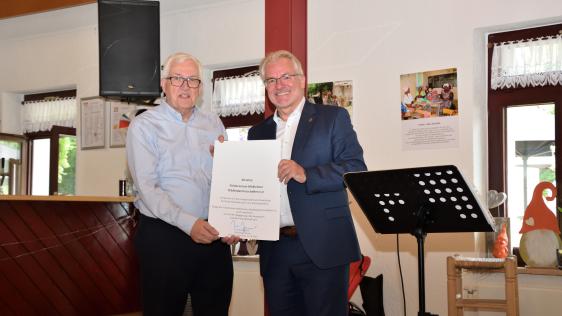 Oberbürgermeister Marc Buchholz (rechts) überreicht dem Vorsitzenden des Fördervereins Mülheimer Städtepartnerschaften e. V., Dr. Gerhard Ribbrock (links), eine Urkunde anlässlich des 30-jährigen Jubiläums des Vereins.
