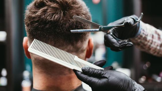 Ein Mann lässt sich beim Friseur die Haare schneiden