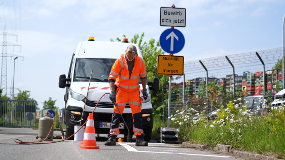 Ein Mitarbeiter des Bauhofs bringt eine Markierung auf die Straße auf.