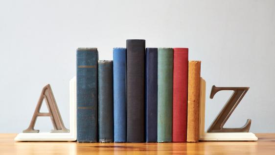 Aufgereihte Bücher, aufrecht gehalten von zwei Buchstützen in den Buchstaben A (links) und Z (rechts).