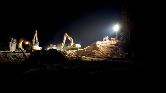 Bagger bei Nacht im Licht der Flutlichtstrahler.