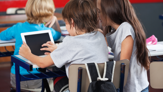 Schulkinder arbeiten mit einem Tablet im Schulunterricht