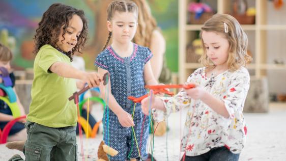 Kinder spielen mit Holz-Marionetten