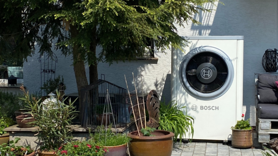 Hund schläft vor Wärmepumpe