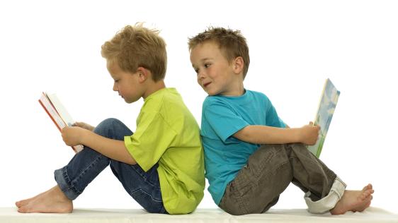 Gezeigt werden 2 Kinder mit einem Buch