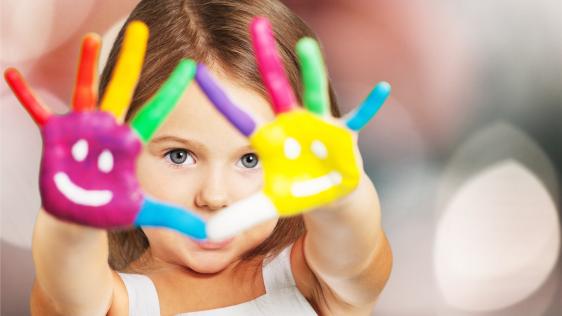 Kleines Mädchen hält ihre bunt bemalten Handflächen in die Kamera. 