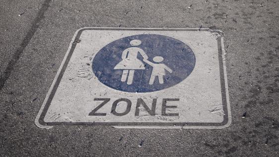 Symbol einer Fußgängerzone auf Asphalt.