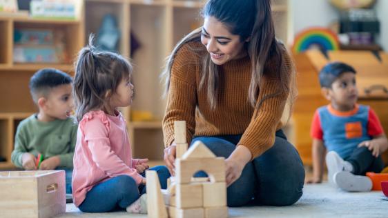 eine Erzieherin, die mit Kindern spielt