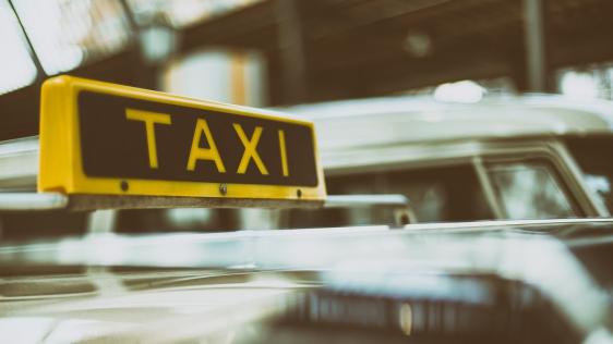 Taxi mit Taxischild auf dem Dach 