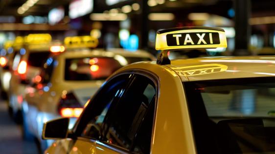 Taxi mit Taxischild auf dem Dach 