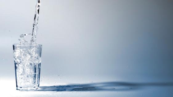 Ein Glas wird mit frischem Trinkwasser gefüllt.