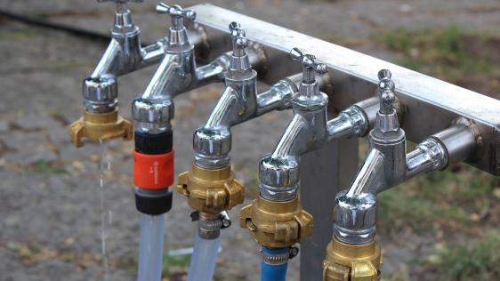Wasserhähne, angeschlossen an einem Brunnen.