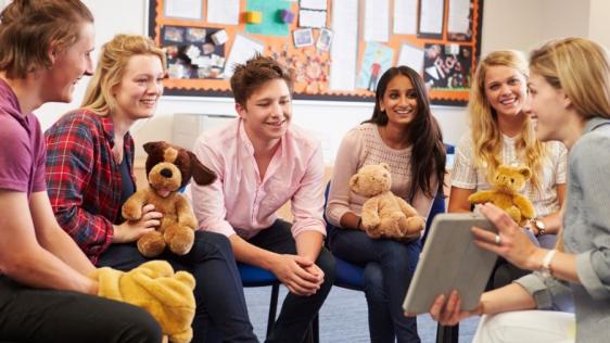 Weiterbildungskurs einer Gruppe von Tagespflegepersonen. Sie halten Stofftiere und besprechen aktuelle Entwicklungen und vertiefte Kenntnisse in den Bereichen Kinder mit besonderem Förderbedarf, Integration, Sprachförderung, Bewegungserziehung, frühe Förderung (Frühwarnsystem) oder Hilfen zur Erziehung (Kindeswohl).