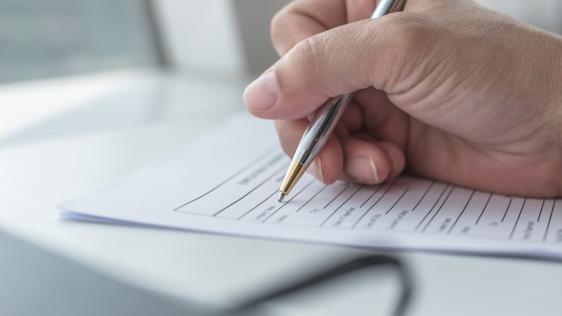 Eine Hand füllt ein Formular aus