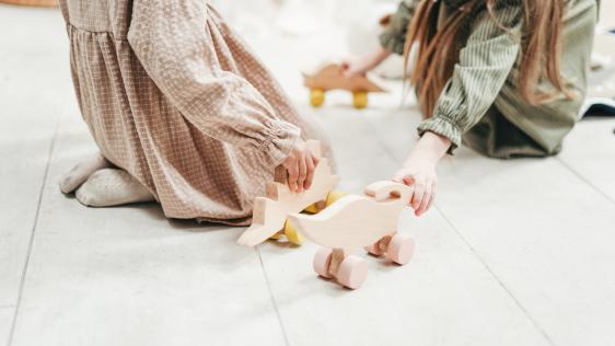 Kinder die mit Holztieren spielen