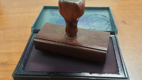 Stempel auf einem Stempelkissen als Symbol für die Ausstellung von Führungszeugnissen 