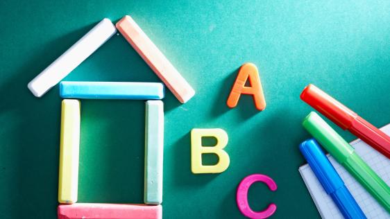 ein zusammengelegtes Haus aus bunter Kreide. Daneben die Buchstaben A, B und C