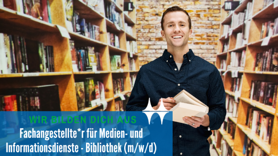 Das Bild zeigt einen jungen Mann, der zwischen Bücherregalen steht. In seinen Händen hält er ein Buch. Er lächelt in die Kamera.