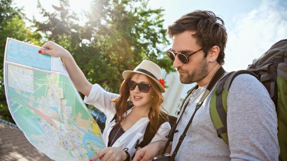 Zwei junge Touristen mit Rucksäcken besichtigen zusammen eine Stadt.