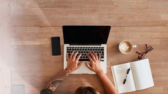 Eine Person trägt an ihrem Laptop einen Veranstaltungstermin online ein.