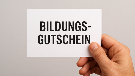 Hand hält eine Karte mit dem Wort "Bildungsgutschein"
