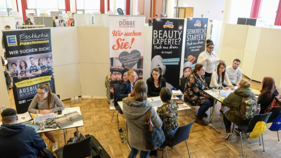Besucher einer Jobmesse. Infostände und Besucher.
