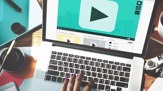 Handeingabe auf Laptop mit Play-Taste auf dem Bildschirm