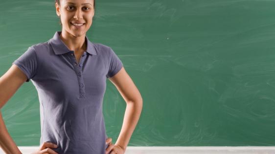 Das Foto zeigt eine junge Lehrerin vor einer Schultafel