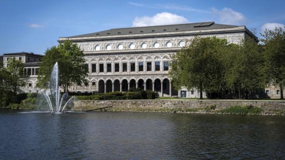 Im Vordergrund die Ruhr mit Fontäne. Im Hintergrund die Rückansicht der Stadthalle.