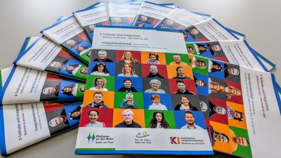 Gedruckte Exemplare des Integrationskonzepts im Halbkreis aufgefächert