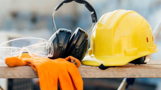 Ein Baustellenhelm, eine Baustellenbrille und Ohrenschützer
