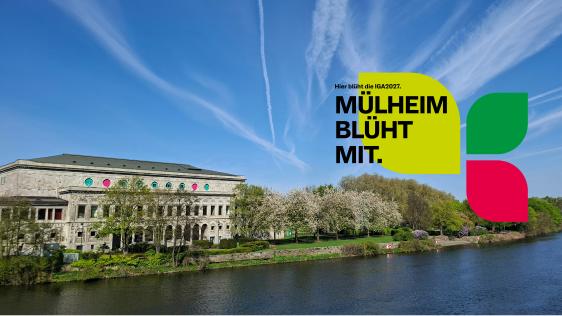 Stadthalle Mülheim ist zu sehen mit Blick von der Schloßbrücke; im Vordergrund ist die Ruhr zusehen; es ist ein Logo mit Blütenblättern und dem Text: Hier blüht die IGA 2027. Mülheim blüht mit. zu sehen