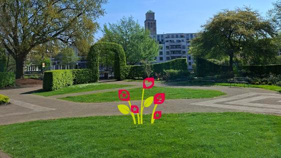 Foto aus der MüGa im Vordergrund ist eine Wiese zu sehen. Auf dieser sind Blumen als Symbol eingefügt.