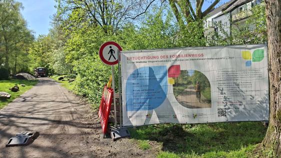 Foto zeigt Baustellenbanner am Fossilienweg, dieser wird auf dem Foto umgebaut