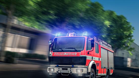 Ein Feuerwehrauto ist auf dem Weg zu einem Einsatz durch die Stadt.